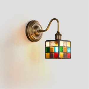 Handcrafted stained glass wall sconce with vintage brass finish and geometric cube shade.