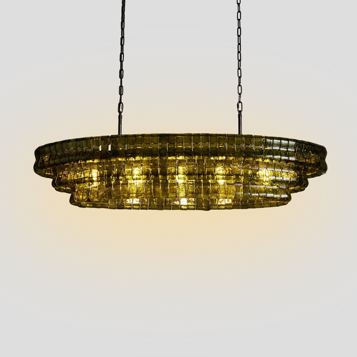 Tiered Olive Green Glass Pendant Light 1 Modern tiered olive green glass pendant light with iron frame hanging over a dining table.