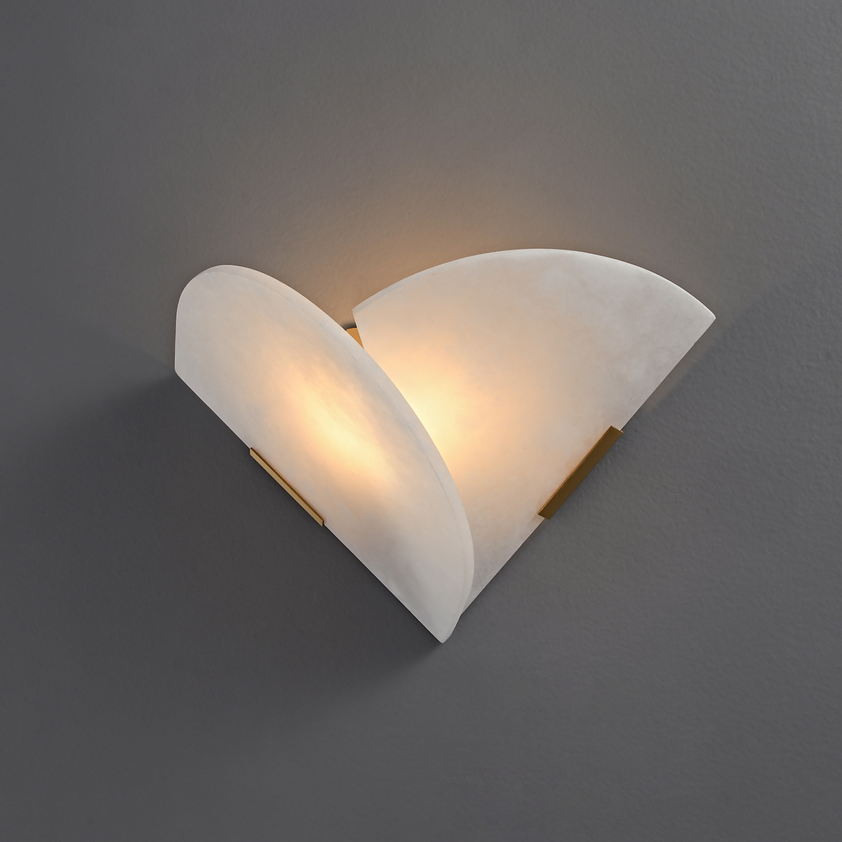Modern Alabaster Wall Sconce 2 Luxury white marble-textured wall light with gold hardware casting a warm glow on a gray wall.